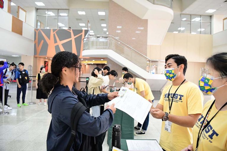 foreigner student being ground staff giving the boarding pass to Taiwanese students
