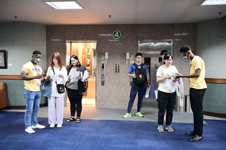 two foreigner student being the ground staff to check boarding pass